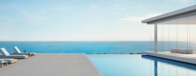 Luxury beach house with sea view swimming pool and terrace in modern design, Lounge chairs on wooden floor deck at vacation home or hotel - 3d illustration of contemporary holiday villa exterior